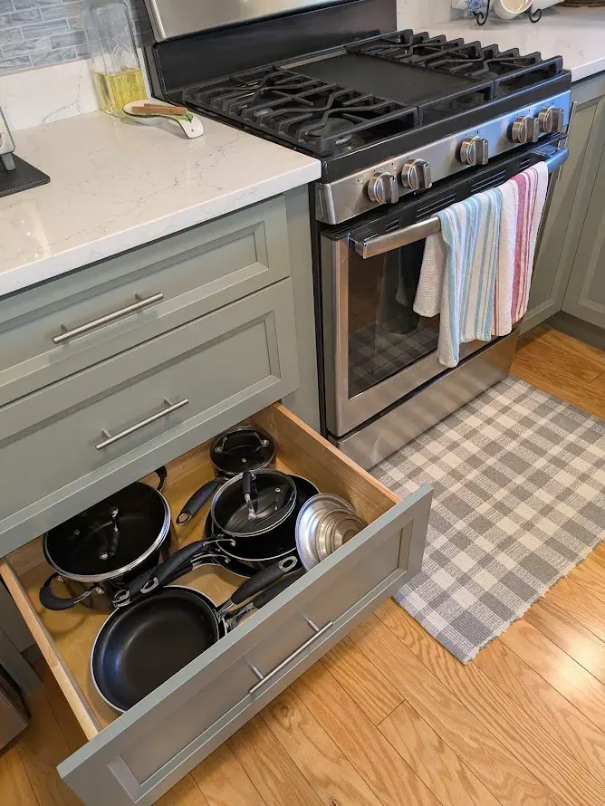 Kitchen: deep drawer holding pots and pans, open beside the gas range.